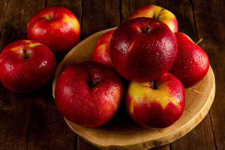 Fresh ripe red apples on a wooden table, side view, a rustic styleの写真素材