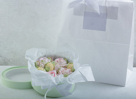 A bouquet of marshmallow flowers - marshmallows in a hatbox on a light backgroundの写真素材