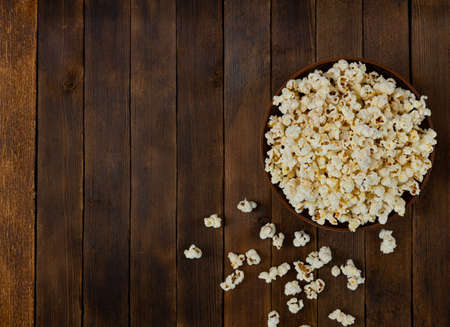 A bowl of delicious popcorn on a wooden table, natural delicious food for watching a movieの写真素材