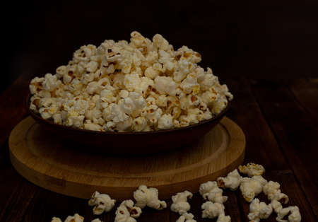 A bowl of delicious popcorn on a wooden table, natural delicious food for watching a movieの写真素材