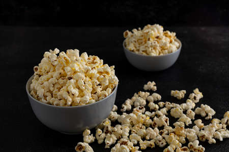A bowl of delicious popcorn on a dark background, natural delicious food for watching a movieの写真素材