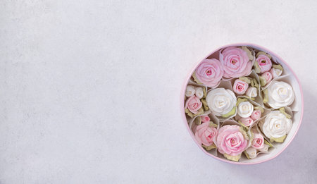 zephyr bouquet of flowers in a pink box on a light background, top view, copy space, holiday...