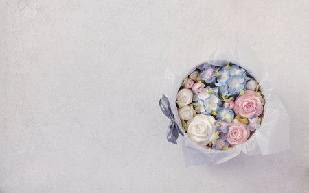 zephyr bouquet of flowers in a pink box on a light background, top view, copy space, holiday concept.の写真素材