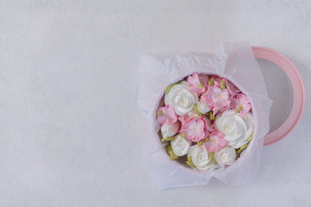 Zephyr bouquet of flowers in a pink box on a gray background