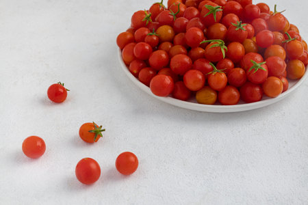 Red cherry tomatoes in a white dish on a light