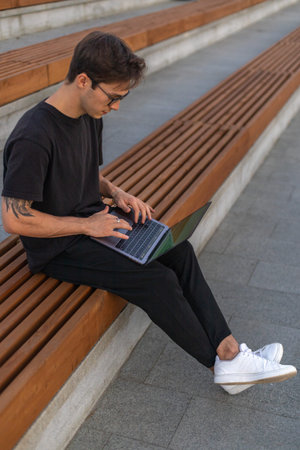 A student is working at a laptop in the park.
