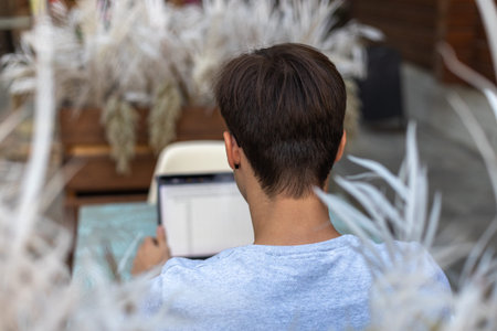 A student is working at a laptop in the park.