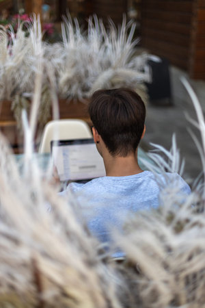 A student is working at a laptop in the park.
