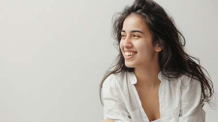 An image of a happy Woman in white clothes on a white background and Looking at the Camera.の素材