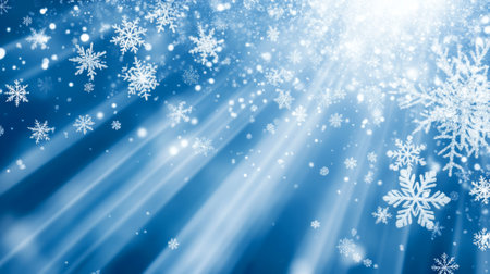 Blue background with white snowflakes and rays of light. Space for text. Winter season, holiday celebration.の素材