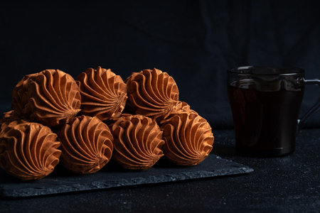 Coffee Zephyr accompanied by elegantly designed pastries on a dark slate surface, highlighting...