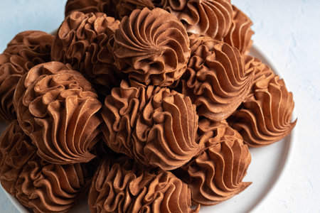 A delightful arrangement of coffee marshmallows on a white plate, highlighting their intricate swirled design and rich texture, ideal for dessert presentations and culinary inspirationの写真素材