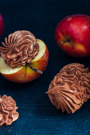 Fresh red apples are beautifully paired with chocolate cream swirls, creating an enticing dessert display that emphasizes the harmony of flavors and texturesの写真素材