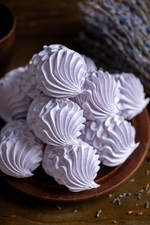 Homemade lavender zephyr beautifully arranged in a rustic wooden bowl, highlighting soft textures and colors, ideal for culinary presentations and dessert themesの写真素材