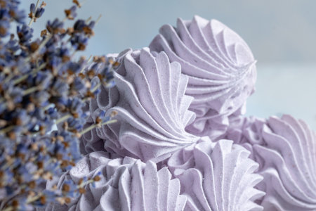 Homemade lavender zephyr is elegantly displayed next to dried lavender flowers on a light background, creating a serene and inviting dessert scene with copy spaceの写真素材