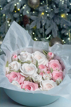 Beautiful arrangement of pink and white roses in a light blue gift box, surrounded by festive decorations, creating a charming holiday atmosphere with soft lightingの写真素材