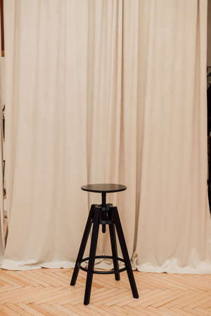 Black round wooden chair stands in the roomの写真素材