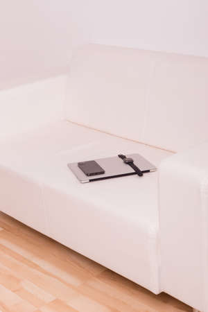 The phone and watch are on top of the laptop. High quality photoの写真素材