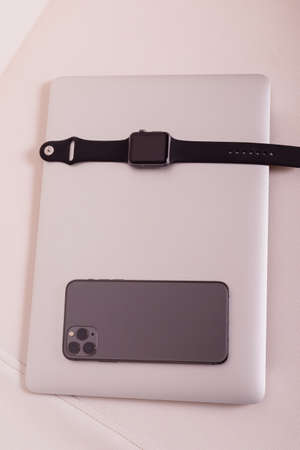 The phone and watch are on top of the laptop. High quality photoの写真素材