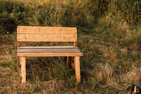 Wooden bench stands in the village in the grass. High quality photoの写真素材