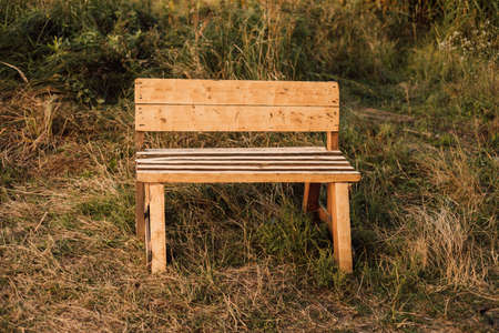 Wooden bench stands in the village in the grass. High quality photoの写真素材