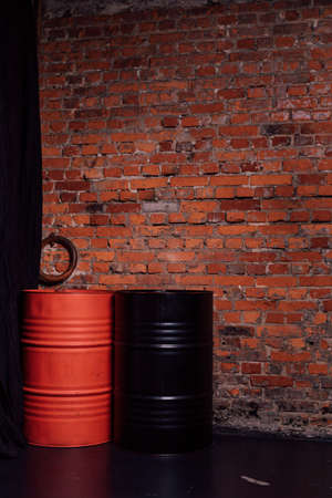 Two barrels of red and black stand against the background of a brick wallの写真素材