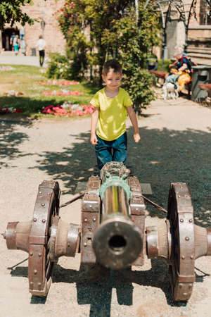 A little boy stay on top of a historic cannonの写真素材