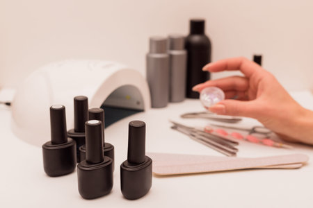 Manicure master holds manicure decor in his handsの写真素材