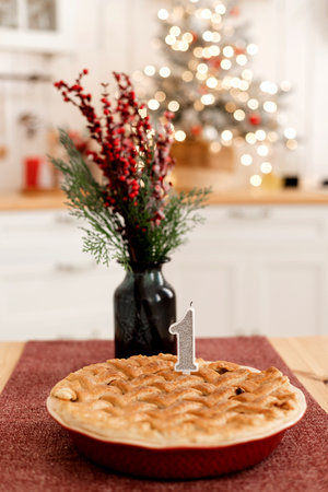 A pie with a candle and a vase of flowers. Celebrating the first birthdayの写真素材
