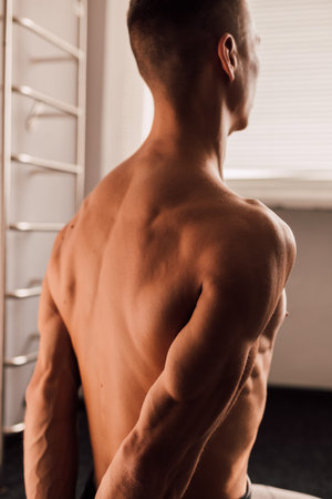 A man with a naked torso sits on the floor. Athletic body. Sports Yoga Exercises