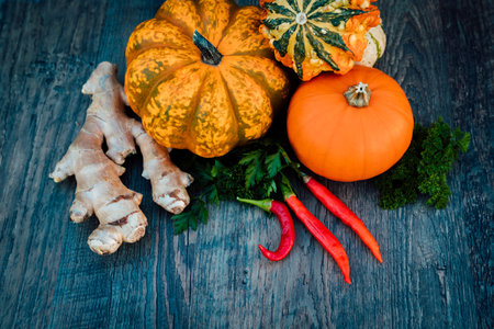 Chili peppers, ginger, pumpkins, parsley autumn vegetables on a table. Top viewの写真素材