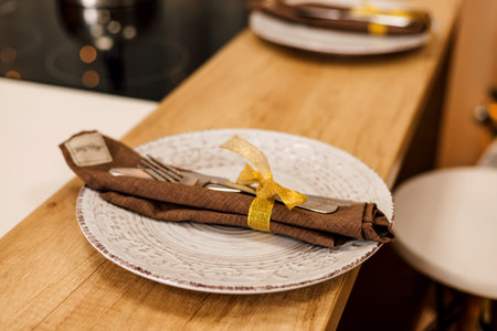 Beautiful white porcelain plate with knife and fork on a wooden tableの写真素材