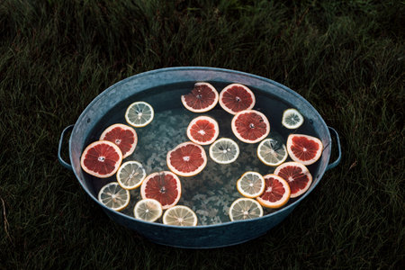 Sliced grapefruits and lemons in water in a basin