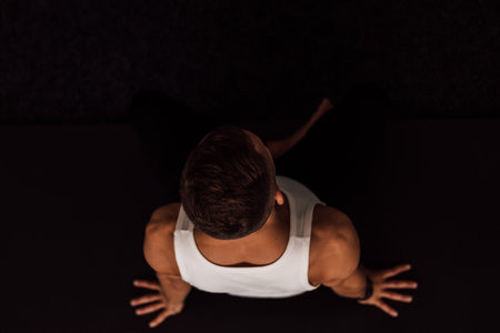 A man holds his knees with his hands doing yoga. Top viewの写真素材