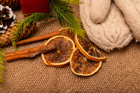 Christmas composition. Christmas cones, mittens, cinnamon, oranges on burlapの写真素材