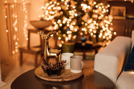 Wooden round table in the living room with cups and reindeer for Christmasの写真素材