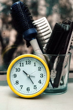 Alarm clock on the windowsill with hairdressers combs. Barbershopの写真素材