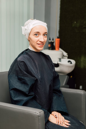 A woman with a towel on head. Hair washing, treatment in the hairdressing salonの写真素材