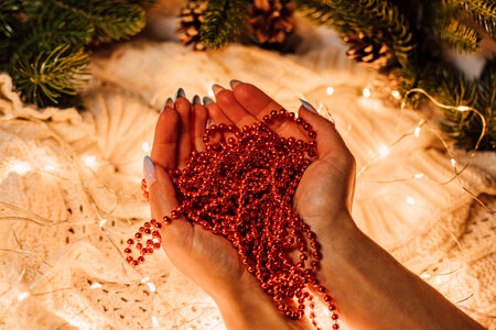 Christmas composition. Womens hands with red beadsの写真素材