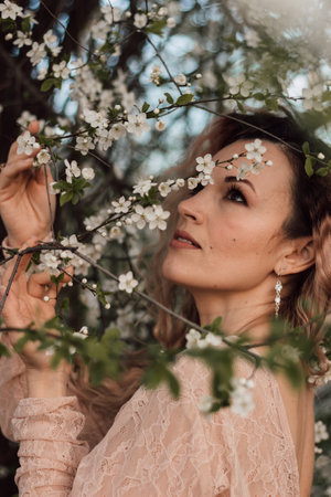 A beautiful woman in a spring garden near cherry blossoms. Flowering gardenの写真素材