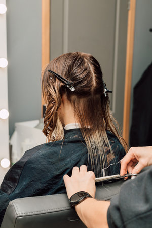 A hairdresser cuts a blondes hair in a beauty salon. Womens haircutの写真素材