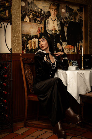 Glamorous woman, lady in black dress smoking in restaurant. Luxury Living. High quality photo
