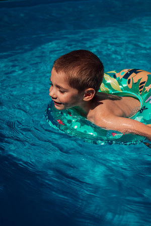 A little boy with a circle bathes in clear blue water. Swimming in the pool. High quality photoの写真素材