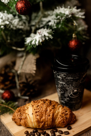 Coffee to go and croissant near the Christmas tree. New Year's Eve Sweets. High quality photoの写真素材