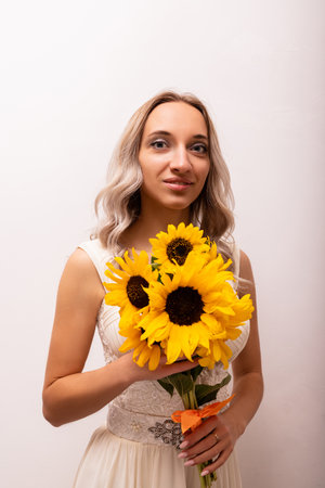 Bride in a wedding dress with a bouquet of sunflowers. Beautiful woman. Floristics. High quality photoの写真素材