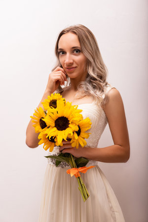 Bride in a wedding dress with a bouquet of sunflowers. Beautiful woman. Floristics. High quality photoの写真素材