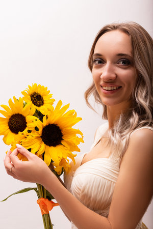 Bride in a wedding dress with a bouquet of sunflowers. Beautiful woman. Floristics. High quality photoの写真素材