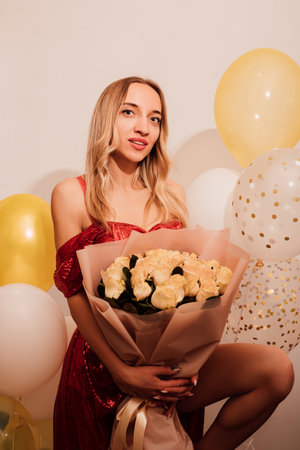 Young attractive woman in long dress with roses and balloons. Party, celebration. High quality photoの写真素材
