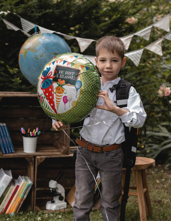 A first-grader. The boy goes to school. A schoolboy holds a balloon in his hands. High quality photoの写真素材