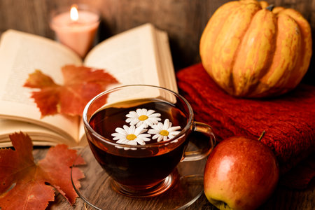 Autumn composition, tea, pumpkins, candle on the table. Autumn comfort at home. High quality photoの写真素材